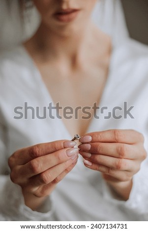 Close-up of an elegant diamond ring on a woman's finger with a modern manicure, sunlight. Love and wedding concept. Soft and selective focus.
