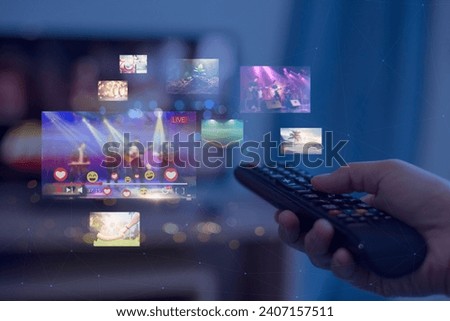 Close-up of hands using remote smart tv on blurred smart tv with video on demand as background Royalty-Free Stock Photo #2407157511