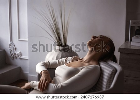 Depressed lone woman suffering from mental health lying in living room at shadow. Illness young lady with emotional stress in armchair at home. Mental health and depression concept. Copy ad text space Royalty-Free Stock Photo #2407176937
