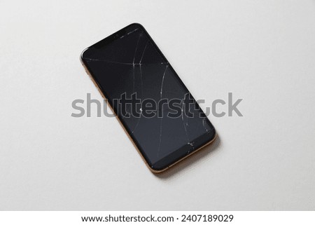 Mobile smartphone with broken display on colored background