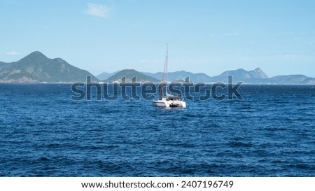 Nautical catamaran in the sea of Rio de Janeiro, with mountains in the background.