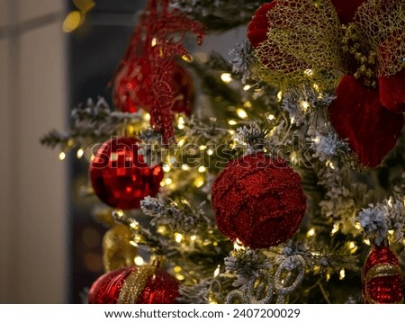 Red balloons with scarlet flowers and yellow lights. Christmas tree branches covered with snow add freshness to the picture
