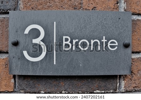3 Bronte. Welsh slate door numbers and names on a victorian brick wall