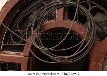Spiral of entangled optical fiber cable for internet tied on a wooden window frame Royalty-Free Stock Photo #2407202919