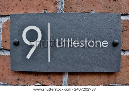 9 Littlestone. Welsh slate door numbers and names on a victorian brick wall