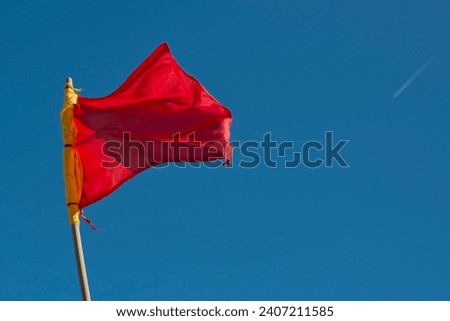 red alert flag weaving on the sky background