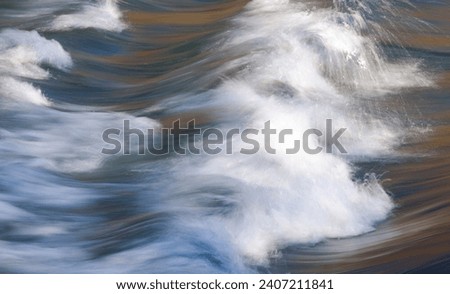 Golden light reflected in river water and soft rapids using a slow shutter speed
