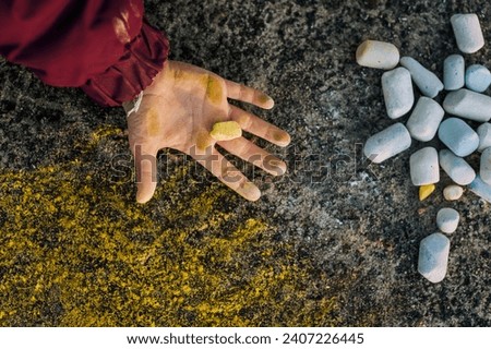 Ukrainian girl, child shows dirty, smeared hands, palms with yellow chalk after drawing a picture on the asphalt. Photography, top view, childhood concept, lifestyle.