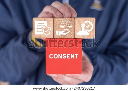 Man holding multi-colored blocks with icons sees word: CONSENT. Medical informed consent concept. Data Privacy Compliance, Consent Management, Personal Data Protection Concept. Royalty-Free Stock Photo #2407230217