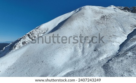 Aerial drone photo of snowed mountain peak as seen at winter in popular European destination