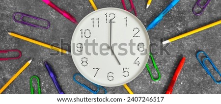 5 o'clock. Banner. Study or business time. Clock  with white clock face on dark background with pencils, pens and paper clips. Concept of study, work