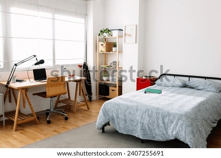 Cozy interior teenager room with bed and desk workplace. Young content creator teenager bedchamber.