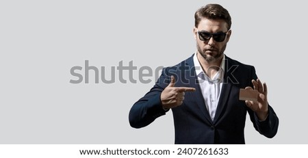 Portrait of businessman showing plastic credit card against grey background. Copyspace blank area for slogan or text. Business and success concept. Banner for header copy space. Poster for web design.