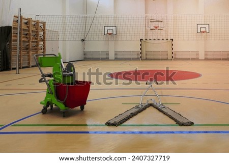 Sports and exercise facilities indoors. Gym. Basketball indoor court, a sports hall, a mop and bucket.