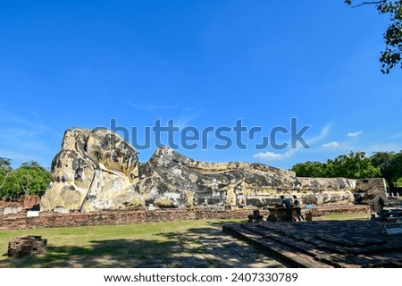A large old reclining Buddha statue made of concrete in Ayutthaya, Thailand.
