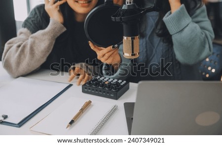 Woman recording a podcast on her laptop computer with headphones and a microscope. Female podcaster making audio podcast from her home studio.