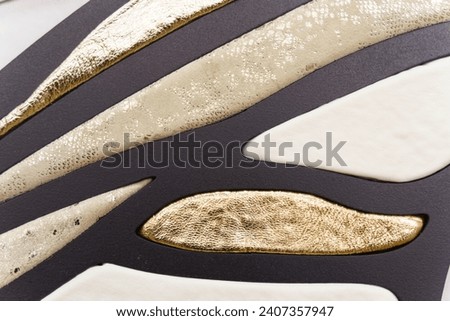 Patterned texture with pieces of leather in white, gold and black used as a classic background. Texture and backgrounds