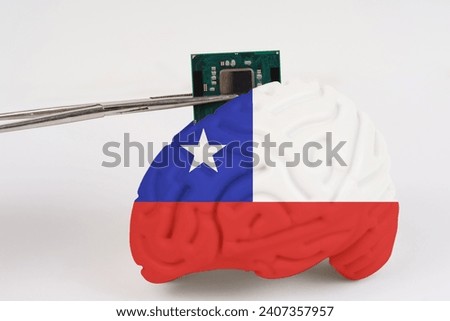 On a white background, a model of the brain with a picture of a flag - Chile, a microcircuit, a processor, is implanted into it. Close-up