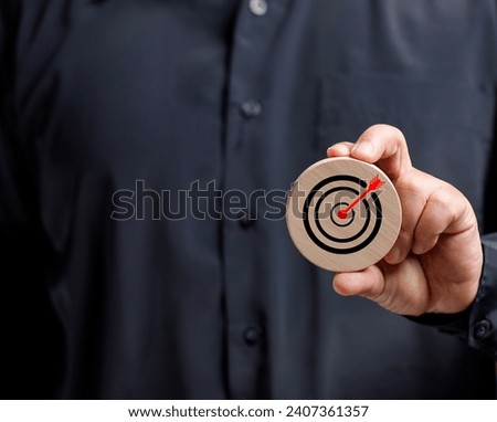 Businessman holds a wooden board with a marketing symbol with a red dart in the middle. Business, Advertising, marketing and targeting. Clear and specific goals.Strategy plan go for success target.