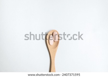 vitamin in wooden spoon on white background, Dietary supplement healthcare product.