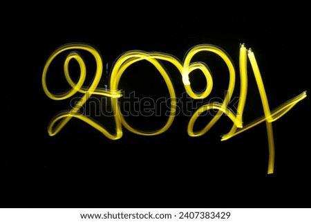 yellow 2024 word light painting on black background.