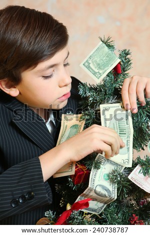 boy in businessman suit with christmas tree and money