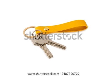 Leather keychain with key ring isolated on white background. Concepts for real estate and moving home or renting property. Buying a property. Mock-up keychain.Copy space. Royalty-Free Stock Photo #2407390729