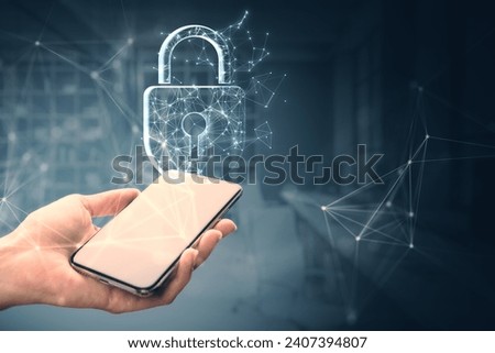 Close up of female hand holding mobile phone with creative digital polygonal shield hologram on blurry gray background. Safety, protection and security concept