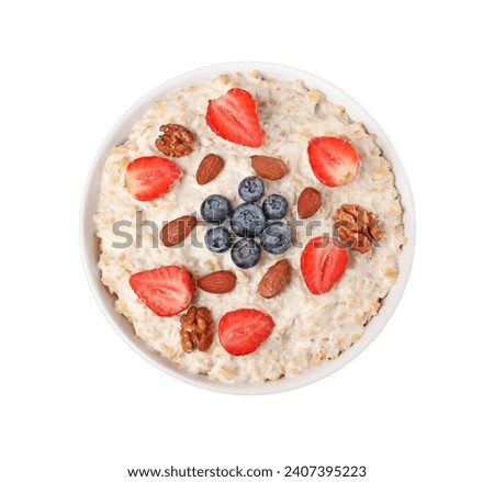 Tasty boiled oatmeal with berries and nuts in bowl isolated on white, top view