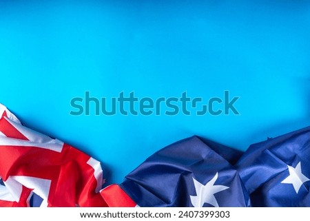 Australia Day greeting card Background with australian flag, silver stars, with text Happy Australia day, paper red, blue, white decor, over blue background copy space Royalty-Free Stock Photo #2407399303