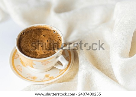 Cup of coffee with chocolate on light white table and beige napkin. Breakfast coffee in bed