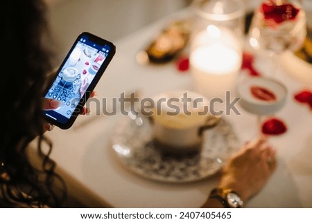 a girl takes a picture of a cocktail in a restaurant. High quality photo