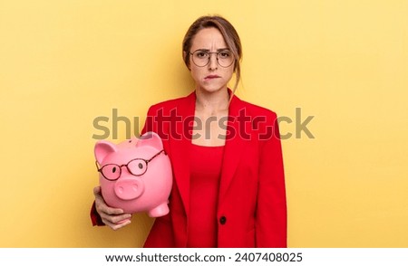 businesswoman looking puzzled and confused. piggy bank concept