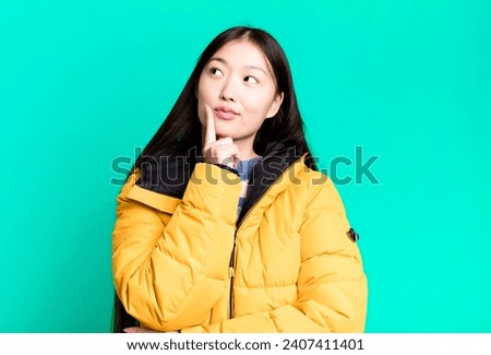 young adult pretty asian woman wearing anorak. winter and cold concept