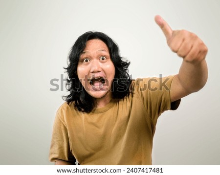 Wow. Front portrait of an attractive half-length man in a plain studio backgroud. The young man with a funny face was shocked emotionally standing .