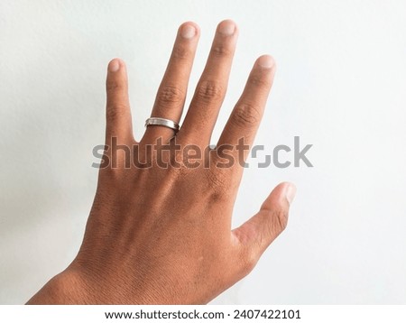 D wedding ring placed on the hand of an Asian man on a white striped background