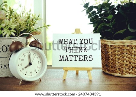 What you think matters text message on paper card with wooden easel, business concept background