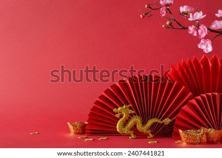 Vibrant Chinese New Year composition: side view feng shui adornments, gold coins, dragon motif, cherry blossoms, fans—set against a red background, inviting text or advertising placement Royalty-Free Stock Photo #2407441821