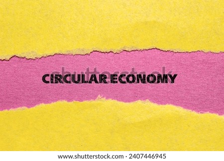 Circular economy lettering on ripped yellow paper with pink background. Business concept photo. Top view, copy space.
