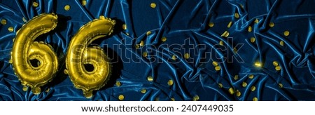 Gold foil balloon number number 66 on a background of blue velvet decoration. Birthday greeting card, inscription sixty-six. Anniversary event. Banner. Copy space Royalty-Free Stock Photo #2407449035