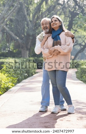 Happy senior couple spending leisure time in park. Royalty-Free Stock Photo #2407472997