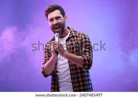 Handsome man with microphone singing in neon lights