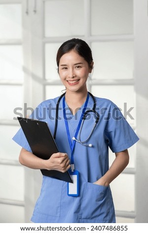 Beautiful Asian female doctor with a stethoscope smile looking at camera cross arm.Nurses wear scrub smile with heartwarming comfortable.Positive emotional and good moment.Health Care Concept Royalty-Free Stock Photo #2407486855