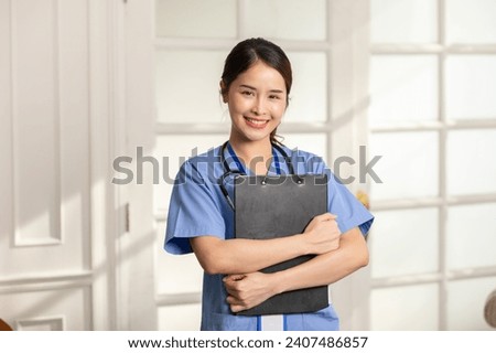 Beautiful Asian female doctor with a stethoscope smile looking at camera cross arm.Nurses wear scrub smile with heartwarming comfortable.Positive emotional and good moment.Health Care Concept Royalty-Free Stock Photo #2407486857