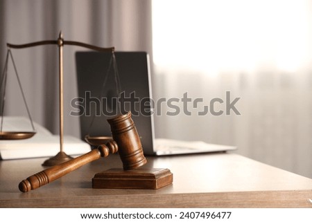 Law concept. Gavel, scales of justice and laptop on wooden table indoors, space for text