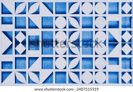 In the picture are wood patterns cut in the form of circles, squares, triangles, and long ovals placed along the blue back
