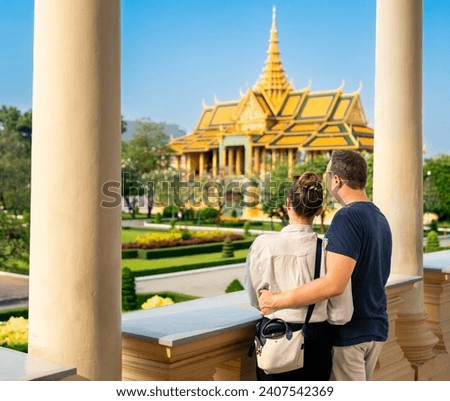 Tourist couple in Phnom Penh, Cambodia. Tourism in Royal Palace. Travel in Asia.  Woman and man visiting landmark. City vacation. Gold building.