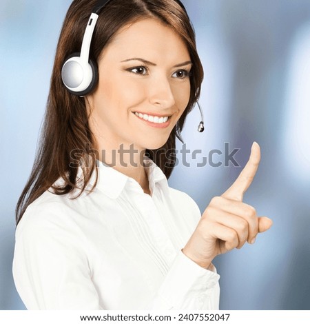 Call center service. Customer support phone sales operator in white confident cloth, headset showing pointing clicking, imaginary or slogan text, blurred office. Square composition photo.