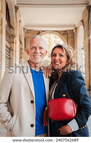 Vertical portrait of a real mature married couple smiling and looking at camera. Mid adult partners staring front with happy expression. Middle aged wife and husband. Spouse and gray hair man. High Royalty-Free Stock Photo #2407562689