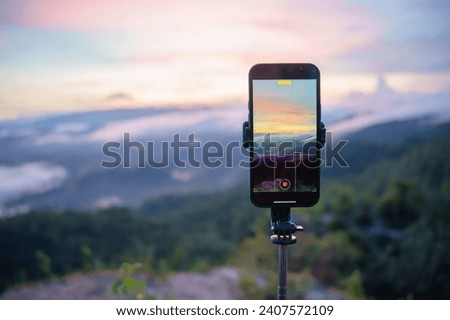 Smartphone Taking photo of mountain stream with  tripod nature view on screen at sunset.